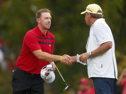 Hunter Mahan of the U.S. (L) shakes hands with International team captain Nick Price of Zimbabwe after he and Brandon Snedeker defeated Inte Hunter Mahan of the U.S. (L) shakes hands with International team captain Nick Price of Zimbabwe after he and Brandon Snedeker defeated Inte