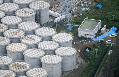 An aerial view shows workers wearing protective suits and masks working atop contaminated water storage tanks at Tokyo Electric Power Co. RE An aerial view shows workers wearing protective suits and masks working atop contaminated water storage tanks at Tokyo Electric Power Co. RE