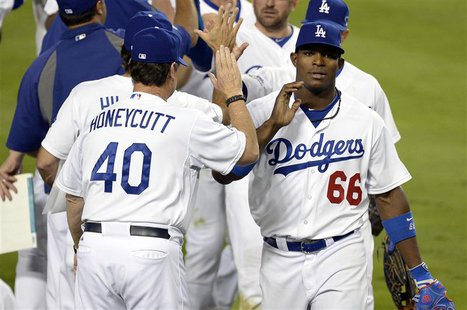 October 6, 2013; Los Angeles, CA, USA; Los Angeles Dodgers right fielder Yasiel Puig (66) celebrates the 13-6 victory against the Atlanta Br October 6, 2013; Los Angeles, CA, USA; Los Angeles Dodgers right fielder Yasiel Puig (66) celebrates the 13-6 victory against the Atlanta Br
