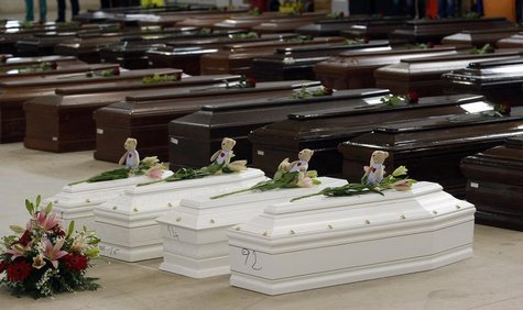 Coffins (in white) of children are seen alongside coffins of other victims from a shipwreck off Sicily, in a hangar of the Lampedusa airport Coffins (in white) of children are seen alongside coffins of other victims from a shipwreck off Sicily, in a hangar of the Lampedusa airport