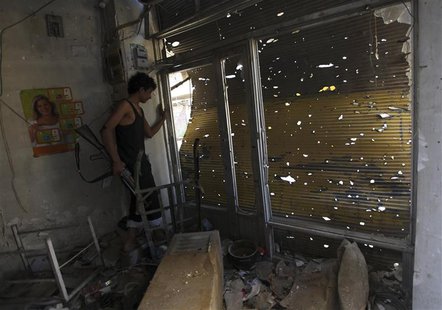 A Free Syrian Army fighter carries his weapon as he peeks out from a damaged shop in Deir al-Zor October 6, 2013. Picture taken October 6, 2 A Free Syrian Army fighter carries his weapon as he peeks out from a damaged shop in Deir al-Zor October 6, 2013. Picture taken October 6, 2