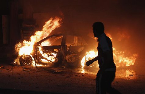 A man looks at a car on fire at the site of a bomb attack in Baghdad October 7, 2013. REUTERS/Ahmed Saad A man looks at a car on fire at the site of a bomb attack in Baghdad October 7, 2013. REUTERS/Ahmed Saad