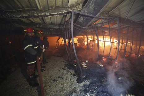 Firefighters stand near a fire as they try to control it inside a garment factory in the Bangladeshi town of Gazipur, 40 km (25 miles) north Firefighters stand near a fire as they try to control it inside a garment factory in the Bangladeshi town of Gazipur, 40 km (25 miles) north