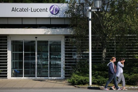 Employees of Alcatel-Lucent walk past an entrance at the company site in Orvault near Nantes, western France, October 8, 2013. REUTERS/Steph Employees of Alcatel-Lucent walk past an entrance at the company site in Orvault near Nantes, western France, October 8, 2013. REUTERS/Steph