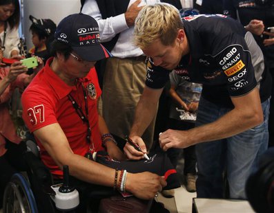 Red Bull Formula One driver Sebastian Vettel of Germany signs his autograph for a fan after speaking at an event at Nissan Motor Co's global Red Bull Formula One driver Sebastian Vettel of Germany signs his autograph for a fan after speaking at an event at Nissan Motor Co's global