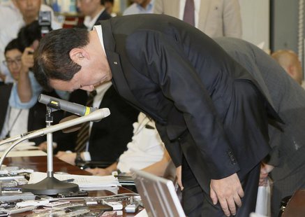 Mizuho Financial Group President Yasuhiro Sato bows during a news conference at the Bank of Japan headquarters in Tokyo, in this photo taken Mizuho Financial Group President Yasuhiro Sato bows during a news conference at the Bank of Japan headquarters in Tokyo, in this photo taken