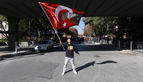 A protester waves a Turkish flag printed with a portrait of Mustafa Kemal Ataturk, the founder of modern Turkey, on a road which leads to a A protester waves a Turkish flag printed with a portrait of Mustafa Kemal Ataturk, the founder of modern Turkey, on a road which leads to a