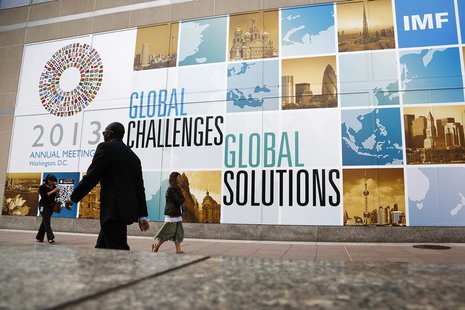 People walk outside the International Monetary Fund headquarters at the start of the annual IMF-World Bank fall meetings in Washington, Octo People walk outside the International Monetary Fund headquarters at the start of the annual IMF-World Bank fall meetings in Washington, Octo
