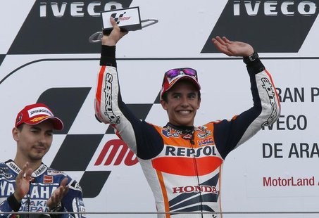 Honda MotoGP rider Marc Marquez (R) celebrates next to Yamaha MotoGP rider Jorge Lorenzo on the podium after winning the Aragon Motorcycling Honda MotoGP rider Marc Marquez (R) celebrates next to Yamaha MotoGP rider Jorge Lorenzo on the podium after winning the Aragon Motorcycling
