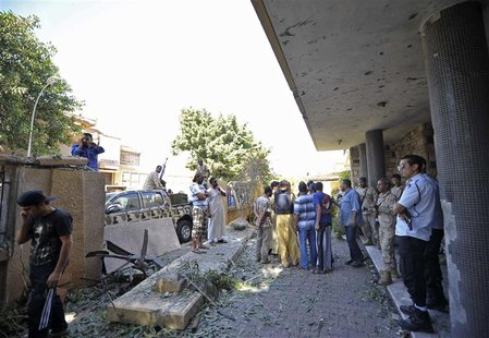 Security personnel and residents gather at the scene of a car bomb explosion at the Swedish consulate in Benghazi October 11, 2013. REUTERS/ Security personnel and residents gather at the scene of a car bomb explosion at the Swedish consulate in Benghazi October 11, 2013. REUTERS/
