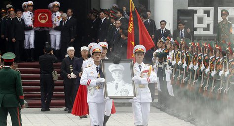 Soldiers hold up the portrait of the late General Vo Nguyen Giap as his coffin is carried during his funeral at the National Funeral House i Soldiers hold up the portrait of the late General Vo Nguyen Giap as his coffin is carried during his funeral at the National Funeral House i