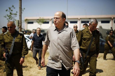 Israeli Defense Minister Moshe Yaalon (C) walks next to Israel's armed forces chief Major-General Benny Gantz (R) during a visit to a milita Israeli Defense Minister Moshe Yaalon (C) walks next to Israel's armed forces chief Major-General Benny Gantz (R) during a visit to a milita