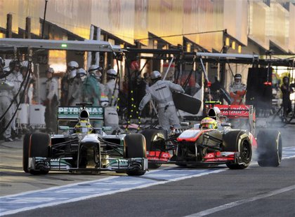 Mercedes Formula One driver Nico Rosberg (L) of Germany disturbs McLaren Formula One driver Sergio Perez of Mexico on the pit lane during th Mercedes Formula One driver Nico Rosberg (L) of Germany disturbs McLaren Formula One driver Sergio Perez of Mexico on the pit lane during th