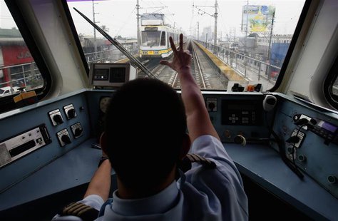 A train operator on Southeast Asia's first light rail transit (LRT) network, which is 29-years-old, signals to a colleague in another train A train operator on Southeast Asia's first light rail transit (LRT) network, which is 29-years-old, signals to a colleague in another train
