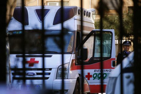 A policeman is seen through a fence as he stands beside an ambulance believed to be carrying Ji Zhongxing, the man who set off home-made exp A policeman is seen through a fence as he stands beside an ambulance believed to be carrying Ji Zhongxing, the man who set off home-made exp