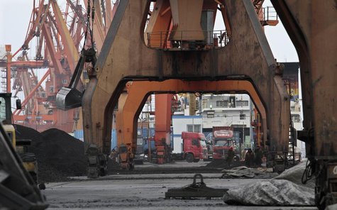 Stevedores walk under giant cranes as they wait to load coal imported from North Korea onto trucks at Dandong port in the Chinese border cit Stevedores walk under giant cranes as they wait to load coal imported from North Korea onto trucks at Dandong port in the Chinese border cit