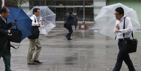 Men struggle against strong wind and rain caused by approaching Typhoon Wipha at a business district in Tokyo October 16, 2013. REUTERS/Toru Men struggle against strong wind and rain caused by approaching Typhoon Wipha at a business district in Tokyo October 16, 2013. REUTERS/Toru