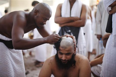 A Muslim pilgrim has his head shaved after casting pebbles at a pillar that symbolizes Satan during the annual haj pilgrimage, on the first A Muslim pilgrim has his head shaved after casting pebbles at a pillar that symbolizes Satan during the annual haj pilgrimage, on the first