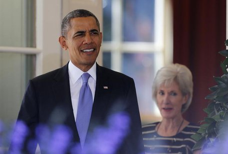 U.S. President Barack Obama walks out to deliver remarks alongside Human Services Secretary Kathleen Sebelius (R) and other Americans the Wh U.S. President Barack Obama walks out to deliver remarks alongside Human Services Secretary Kathleen Sebelius (R) and other Americans the Wh