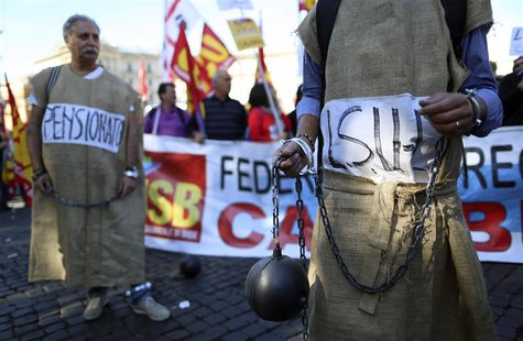 Demonstrators dressed to represent prisoners, hold chains and a mock cannonball during a protest against the reforms by the Italian governme Demonstrators dressed to represent prisoners, hold chains and a mock cannonball during a protest against the reforms by the Italian governme
