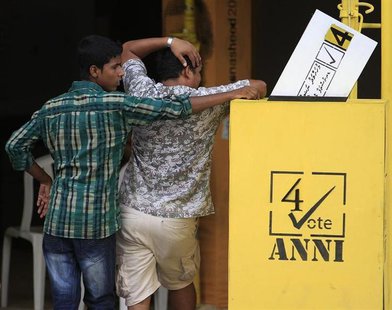 Men stand next to a dummy model of a ballot box, promoting the election campaign of Maldivian presidential candidate Mohamed Nasheed, outsid Men stand next to a dummy model of a ballot box, promoting the election campaign of Maldivian presidential candidate Mohamed Nasheed, outsid
