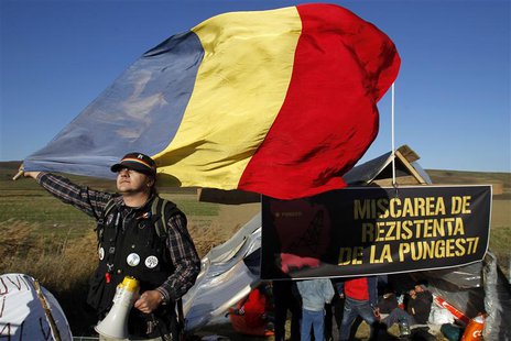 A man holds Romania's national flag in front of a tent installed on the empty lot where U.S. oil major Chevron plans to search for shale gas A man holds Romania's national flag in front of a tent installed on the empty lot where U.S. oil major Chevron plans to search for shale gas