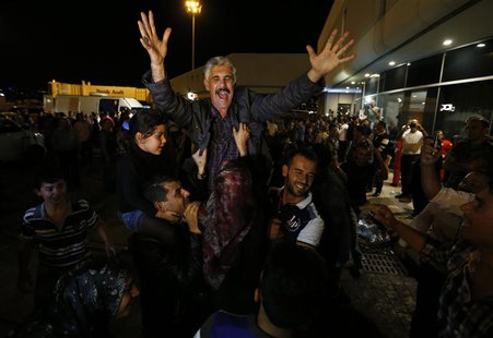 One of the nine newly released Lebanese hostages, who were held by rebels in northern Syria, gestures as he is welcomed by his relatives upo One of the nine newly released Lebanese hostages, who were held by rebels in northern Syria, gestures as he is welcomed by his relatives upo