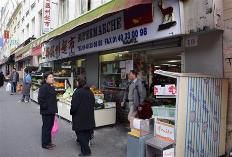 People stand outside a supermarket bearing a Chinese signboard in the Belleville district in Paris, October 17, 2013. Picture taken October People stand outside a supermarket bearing a Chinese signboard in the Belleville district in Paris, October 17, 2013. Picture taken October