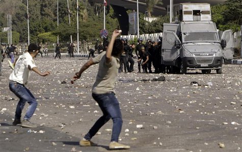 Protesters throw stones during clashes with riot police in front of the main offices of Al-Azhar University in Cairo October 20, 2013. REUTE Protesters throw stones during clashes with riot police in front of the main offices of Al-Azhar University in Cairo October 20, 2013. REUTE