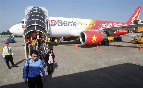Vietjet Air passengers exit the aircraft after arriving at Tan Son Nhat airport in Vietnam's southern Ho Chi Minh city October 20, 2013. REU Vietjet Air passengers exit the aircraft after arriving at Tan Son Nhat airport in Vietnam's southern Ho Chi Minh city October 20, 2013. REU