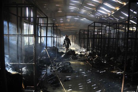 A firefighter inspects a burnt garment factory after a fire in the Bangladeshi town of Gazipur, 40 km (25 miles) north of Dhaka October 9, 2 A firefighter inspects a burnt garment factory after a fire in the Bangladeshi town of Gazipur, 40 km (25 miles) north of Dhaka October 9, 2
