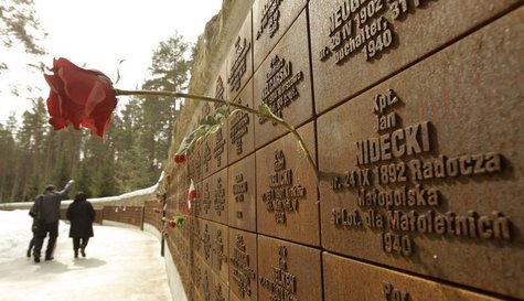 A flower is attached to a wall inscribed with the names of killed Polish officers during a commemoration ceremony at a memorial complex in K A flower is attached to a wall inscribed with the names of killed Polish officers during a commemoration ceremony at a memorial complex in K