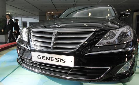 An employee of Hyundai Motor walks past the company's luxury sedan 'Genesis' displayed for visitors after its annual general meeting of stoc An employee of Hyundai Motor walks past the company's luxury sedan 'Genesis' displayed for visitors after its annual general meeting of stoc