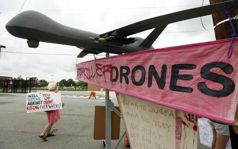 Demonstrators stand beside a mock drone outside the gates of Fort McNair where President Barack Obama will speak at Washington's National De Demonstrators stand beside a mock drone outside the gates of Fort McNair where President Barack Obama will speak at Washington's National De