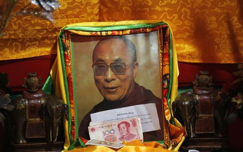 Chinese bank notes from faithful are placed in front of a portrait of Tibetan spiritual leader Dalai Lama at Kumbum monastery, where Dalai L Chinese bank notes from faithful are placed in front of a portrait of Tibetan spiritual leader Dalai Lama at Kumbum monastery, where Dalai L