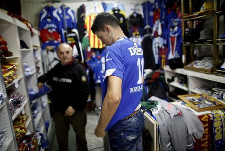 A tourist tries on a Bosnian national soccer team jersey at a shop in the old part of the city, Bascarsija, in Sarajevo, October 16, 2013. R A tourist tries on a Bosnian national soccer team jersey at a shop in the old part of the city, Bascarsija, in Sarajevo, October 16, 2013. R