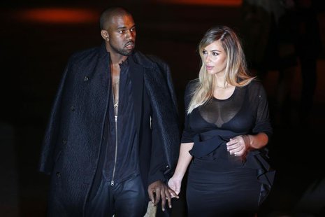 U.S. musician Kanye West (L) and companion Kim Kardashian arrive at the Givenchy Spring/Summer 2014 women's ready-to-wear fashion show durin U.S. musician Kanye West (L) and companion Kim Kardashian arrive at the Givenchy Spring/Summer 2014 women's ready-to-wear fashion show durin