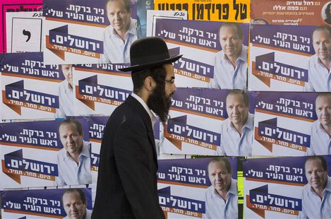 An ultra-Orthodox Jewish man walks past municipal elections campaign posters of Jerusalem Mayor Nir Barkat in Jerusalem October 22, 2013. RE An ultra-Orthodox Jewish man walks past municipal elections campaign posters of Jerusalem Mayor Nir Barkat in Jerusalem October 22, 2013. RE