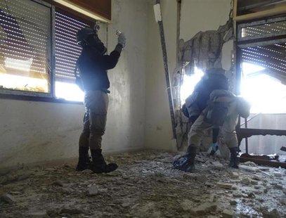 U.N. chemical weapons experts, wearing gas masks, inspect one of the sites of an alleged chemical weapons attack in the Damascus' suburb of U.N. chemical weapons experts, wearing gas masks, inspect one of the sites of an alleged chemical weapons attack in the Damascus' suburb of