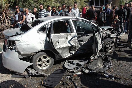 People gather around the wreckage of a car after a car bomb exploded in al-Ahram street near al-Nuzha roundabout in Homs, in this handout di People gather around the wreckage of a car after a car bomb exploded in al-Ahram street near al-Nuzha roundabout in Homs, in this handout di