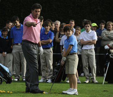 Spanish golfer Jose Maria Olazabal instructs a child during a golf clinic in La Barganiza, near Oviedo, northern Spain October 23, 2013. REU Spanish golfer Jose Maria Olazabal instructs a child during a golf clinic in La Barganiza, near Oviedo, northern Spain October 23, 2013. REU