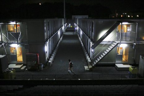 A man walks among temporary housing structures erected for workers at J-Village, a soccer training complex now serving as an operation base A man walks among temporary housing structures erected for workers at J-Village, a soccer training complex now serving as an operation base