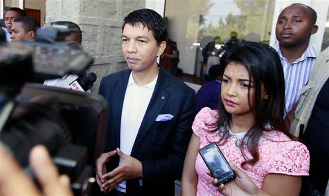 Madagascar's President Andry Rajoelina (C) flanked by his wife Mialy address the media after casting their ballots at a polling centre in Am Madagascar's President Andry Rajoelina (C) flanked by his wife Mialy address the media after casting their ballots at a polling centre in Am