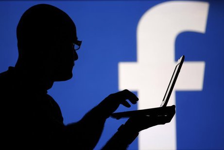 A man is silhouetted against a video screen with an Facebook logo in this photo illustration taken in the central Bosnian town of Zenica, Au A man is silhouetted against a video screen with an Facebook logo in this photo illustration taken in the central Bosnian town of Zenica, Au