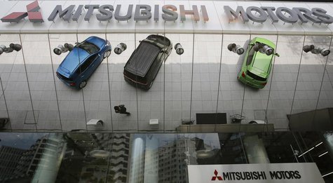 Mitsubishi Motors Corp's vehicles and a passer-by are reflected on an external wall at the company headquarters in Tokyo May 23, 2013. REUTE Mitsubishi Motors Corp's vehicles and a passer-by are reflected on an external wall at the company headquarters in Tokyo May 23, 2013. REUTE