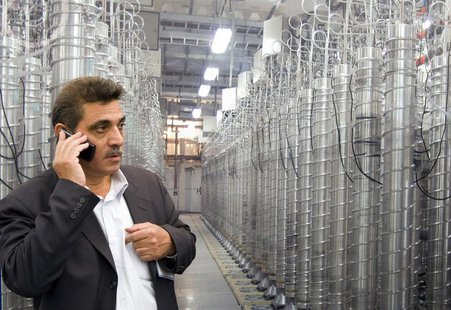 An official from Iran's Atomic Energy Organization speaks on his mobile phone in front of uranium enriching centrifuges at an exhibition of An official from Iran's Atomic Energy Organization speaks on his mobile phone in front of uranium enriching centrifuges at an exhibition of