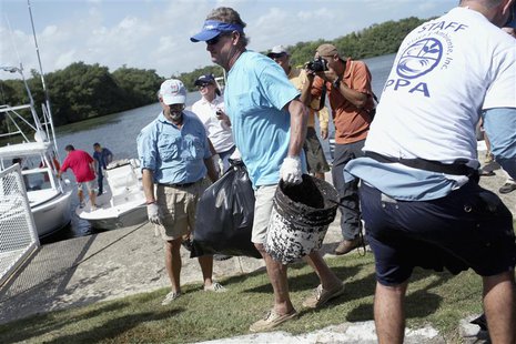 U.S. artist and conservationist Guy Harvey (C) leads a group of volunteers along the San Juan estuary system for the second "mega cleanup" o U.S. artist and conservationist Guy Harvey (C) leads a group of volunteers along the San Juan estuary system for the second "mega cleanup" o