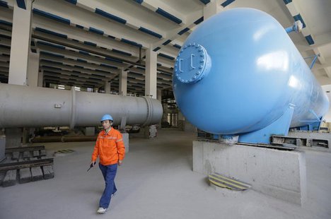 A worker walks among gas storage tanks at the construction of Beijing Jingxi Gas-fired Thermal Power Co Ltd, which will be used to replace t A worker walks among gas storage tanks at the construction of Beijing Jingxi Gas-fired Thermal Power Co Ltd, which will be used to replace t