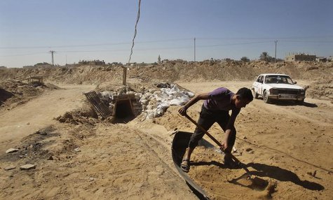 A tunnel worker shovels sand outside a smuggling tunnel on the border between Egypt and the southern Gaza Strip October 8, 2013. REUTERS/Ahm A tunnel worker shovels sand outside a smuggling tunnel on the border between Egypt and the southern Gaza Strip October 8, 2013. REUTERS/Ahm