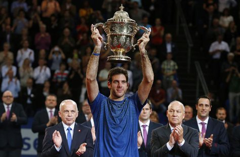 Juan Martin Del Potro (C) of Argentina raises the winner's trophy after he won his final match against Switzerland's Roger Federer at the Sw Juan Martin Del Potro (C) of Argentina raises the winner's trophy after he won his final match against Switzerland's Roger Federer at the Sw